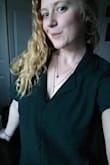 I like how this shirt runs a smidge large, it's a comfortable level of loose. Had I ordered a small I think the sleeves would have been riding up my pits a little bit. Material is very comfortable, looks and feels professional. Upping the professionalism with a camisole with lace trim helps. 
The color is true to the photos on the models. - Strawberry V.