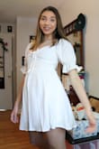 I bought this dress for graduation and it is super cute! It is just a little see-through throughout the dress which I would expect with it being white. The back tag is also pink so you can see it in the back, but my hair covers it. Other than that it is super cute and comfortable! - Lori D.