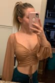 I am absolutely obsessed with this top! I'm fair skinned so I wasn't sure if this color would look good on me but it ended up looking great! It's a little right and since it's ruched it definitely feels small when wearing it. I would buy this top 10 times over again! - Haley W.