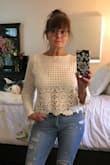 I love this top. I bought both the white and the black. I bought them in a medium and returned the white for a small. I wanted a looser, longer fit. The white runs a little larger than the black one does. - Becky W.