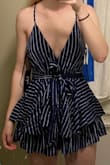 This romper definitely looks as pictured! Very cute, but fits a little loosely and it's pretty short! I probably would've sized down for a tighter fit, but the romper is already very short as is. Like, DO NOT BEND DOWN in this thing or the world will see the entirety of your cheeks. The material also gets a bit wrinkly, but it's less noticeable since the romper is pretty dark. Otherwise, it's super cute and perfect for summer days! - Katie O.