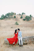 I loved this dress so much!!! It was exactly what I was looking for our engagement session - I wanted it to be flowy and have the perfect shade of red color to contrast with the golden grass in California :). Few issues I ran into - it is long, but I'm also super short. I didn't tailor it prior to the engagement session since I wouldn't really need to walk that much with it (and could just carry it), but if you plan to use it for an event you may need to tailor it on the bottom - which I plan to do now for whenever I use it in the future. The XS was a bit tight around my waist, but I was able to close it and still be comfortable! I think I didn't want to size up in case it would be too big at the shoulder areas and fall off. It is a deep low cut V-neck, so you could stitch it or use a pin to at the V-neck area if you want to. Overall I HIGHLY recommend it - the shade of red is vibrant but not too much, super flowy for pictures, and the material is truly of high quality. - Cindy C.