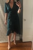 Don't think, just buy! This dress is SO flattering, even if you have a larger chest. It's not too busty, but shows the appropriate amount of cleavage. Wrap dress detailing is super flattering, and the barely there satin is super elegant. Don't wait to buy it, it goes so fast (was on TWO waiting lists for it). I usually wear a M, but saw reviews were that it runs a little large, so the S works perfect. - Madeline R.
