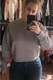 I sized down in this cropped hoodie and it was still too big. The sleeves were huge and the fit was unflattering to me. Too bad bc the color was so cute and the material was so soft. Had to return it - Laura K.