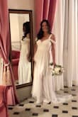 I had been searching for a dress that made me feel va-va-VOOM for my elopement in Tuscany in June. This dress is beautiful, simple and really flattering. Perfect ivory color. It gives me more of an hourglass waistline than the fit and flares, and it's soft and REALLY comfortable. No bra needed but surely some fashion tape! I took a few inches from the bottom leftovers after hemming (it's 3" too long) and created a soft little removable pleated fabric swag like the arm sleeves across the lower bust, just to demurely veil the deepest part of the plunge. I would have been self-conscious otherwise. The seamstress also cut the slit a bit higher to mid-thigh as in my photo and took in a bit from the sides. I wore 3 inch heels. Husband went CRAZY. : ) Looks like a much more expensive dress, really high-quality. - Erin O.