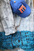 Unfortunately the color is nothing like the blue pictured. As you can see from the attached photo, I placed it next to a blue fuzzy sweater and a blue hat and you can see that this coat is more grey. It runs large so I sized down to a XS and I think that was perfect. Also, you can't see it well, but the lines that run down the coat actually appear pretty obviously when moving in the coat. Overall, I'll wear this coat a few times a year, but is not my favorite purchase from Lulu's. - Anastasia G.