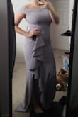 At 5'4 this would have to be hemmed to wear anywhere because it is extremely long. The fabric is really heavy and nice actually and it has some stretch to it but not the shoulders. I bought this for a wedding and I don't think I would have been able to dance in it and it's probably better for a more chill activity. I think it added some focus to my mid-section which I wasn't a huge fan of but the ruffles do help with that. The color is awesome because it looks grey in some light and lavender in others which I loved. Overall I had to return, not a big enough fan. - April L.