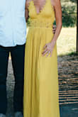 This is a beautiful fall yellow (mustard) dress. I wore for family pictures and it was perfect. The detail is very pretty, a little scalloped edge on the top, cutouts on the waist and the skirt - a perfect flowing bottom. It is long - I am 5,7 and even with heels, it was still long, but I prefer that. The material is thicker than I was expecting - so the quality is very good and no worries about seeing through. It is fairly low cut and so a normal bra would not work. - Kerri E.