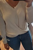 It's not a bad top, just not the right fit for me. The arms are a bit bulky and I didn't like how much room there is in the abdomen, especially combined with how short the top is. Pictured are mid-rise jeans, you can see the bottom of the shirt hits just above the button to the jeans. If I moved my arms at all, my abdomen would easily show. I also have a rather short torso compared to my leg length and I feel like the top just made that more obvious. I really wanted to like this top. - Shahnaz V.