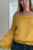 Got like 5 compliments on this shirt today and it is only noon!! I am normally a medium but read the reviews and ordered a small. The small fits PERFECT! So I would size down. The color is so beautiful and the elastic at the top is thick and it actually stays around my shoulder for the most part. Got this on sale as well. Great buy!! Love it! - Christen A.