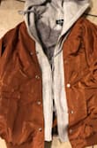 I ordered a medium and small and was swimming in both. Not a huge fan of the look with very shiny buttons and the awkward button down look with how the grey and orange overlap down the front. It's super cozy and warm, but just runs very big and boxy. The burnt orange fabric has a shine to it that appears metallic almost. I would have preferred not being so satin/shiny looking. I will be returning. - Melissa B.