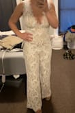 I got this jumpsuit for my bridal shower. It is fun and unique versus the regular white dresses. It was a big hit and everyone loved it. I am 5'2'' and it was quite long on me. I am wearing 5 inch heels in this photo. It is very low in the front but I love it. The straps are a little long as well. I wouldn't change the sizing though! The back is just as low as the front and it is so cute! - Elle S.
