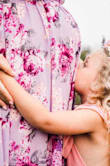 I wore this dress when I was 7 months pregnant for "mommy and me" pics with my 5 year old. The dress is stunning, but comes down really low in the front and is very open underneath the armpits. I had to have the dress taken up at the shoulders (it's made long) and sewn up at the bust. The pictures turned out beautifully, just wanted to include my experience with this dress. - Lindsey C.