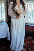 I wore this dress for my elopement and I got many compliments. I'm a true M and early in my pregnancy so my midsection is bloated a bit compared to usual. However, this dress fit well around my waist and was not tight in the least bit. Comfortable to sit in, but super long! 3 inch heels didn't solve the length issue. My chest is smaller so without the ability to wear a regular bra because of the open back it was pretty roomy in the chest area. I may have gotten away with a small in all honesty, but I was short on time so returning wasn't an option. The only complaint really is that the sleeves are kind of baggy, which looked a little awkward. At some angles you couldn't really tell, but I would have preferred a more fitted sleeve. - Amber M.
