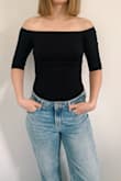 There aren't any cons to this top for me. It has a very thin band of elastic around the neckline which keeps it in place. It won't be sliding down or going anywhere. Very soft and lightweight; it seems like it will be see-through but its not. Very comfortable! Just the right length to tuck in without being a bodysuit. Looks so good paired with jeans or a skirt (I bought the O'Neill Ambrosio skirt to pair it with). Will definitely order more in other colors when they restock! - Courtney V.