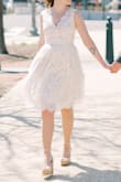 I'm in love with this dress! I wore it for my partner and I's spring elopement. I'm between an XS and S and the S fit perfectly. The bottom has tulle underneath which adds volume, but not too much. It was cold out so I wore it with a denim jacket. - Kristy S.