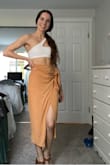 This skirt is super cute. It's a tad tight around my waist (I have a pretty small waist) but I wouldn't get a bigger size because it looked good and fit well otherwise. The color is nice and can be dressed up or down. You could wear it to the beach or out with some heels and a crop top! The slit is a wee bit high so flashing someone is possible. Overall I'm happy with this purchase. - Emily S.