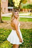I bought this dress for my senior pics and it was absolutely perfect! I got a size medium which I normally always am and it fit very well. I do have swimmer shoulders, so it was very nice to have an open back for my shoulders to have the freedom to move. I found the straps on the shoulders specifically holding up the dress were slightly constricting for me, but not too big of a deal! Very sturdy material and I really liked the low dip in the front. I don't have a ton of bust to help hold anything up in the front, so I really like how it was pretty form fitting as well. Would totally recommend! - Kelsey C.