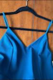 I love this dress! I wore it to a spring wedding. Fabric is not super thick but not too thin either. Very comfortable. Not too short, but it did ride up a tad when I walked, but not so much that it was a problem. Didn't need to wear a bra, but wore covers just incase it got cold. Color was beautiful, but not quite the color shown. Look at some of the photos for better color reference. It's more of a "peacock" blue. Not as green as the image suggests. Overall very happy with my purchase and will wear this dress many more times. Even thinking of ordering more colors! - Kelly W.