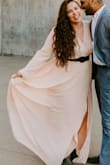 I absolutely love this dress. I am in between sizes due to quarantine but went ahead and sized down because of the reviews! I'm so glad I did! This dress fit exactly how I wanted (flowy). It was a tiny bit too long but I wore heels and managed well enough for an engagement shoot. I may get it hemmed though if I wear for a function. The slit is almost unnoticeable at times but when the dress does open, it is pretty deep but still very classy. Color is amazing! - Michele V.
