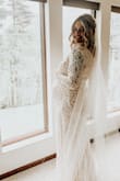 I ordered 2 sizes bigger than my usual size due to being pregnant and it fit perfectly on my belly. I had the sleeves taken in slightly but it was done easily. So happy I was able to buy a wedding dress for this price! I felt beautiful! - Valerie S.