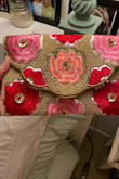 I agree with the reviewer who said the back of the clutch has the allover flowers. I was looking forward to the single flower, as shown in the listing. I am keeping it though because I got it for a wedding I need a clutch for in 2 days so it certainly fits the bill. It is cute/colorful and springy. Don't know yet how long the beads will stay on. But other than the difference in the back of the purse, I am happy with the purchase considering the price. The second photo shows the back (no fold over). - Caroline B.