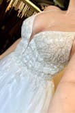 I had hoped this dress would be "the one" but unfortunately I have to return it. I ordered both this and the True Love dress in size 6 and ultimately decided on True Love (I'm eloping and that dress works better). I ordered size 6 with the help of a sales associate. The beaded bodice was far too tight. I almost didn't get it zipped all the way up. It has very beautiful intricate beading which I loved. The tulle skirt poufed out like a ball gown and if the top wasn't so tight, I imagine it would look quite lovely. It's VERY glittery. My fiancé asked why there was glitter all over our floor... it looks pretty though and would photograph nicely. Overall, a super beautiful dress. I possibly would've kept it if I had ordered the correct size. I would advise to size up and then have it tailored to you!! - Kaitlin S.