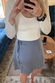 The skirt is a nice material but the color is absolutely not what is pictured. It's like a shiney gray/purple. Not blue at all. I was very disappointed because I bought the skirt since I loved the color so much. The size is also quite large and hangs oddly at the hips. I got a medium but should have gone smaller. - Celeste B.