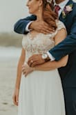 This dress received so many compliments! I bought it once I realized we were going to have some beach play at the wedding. The color is clean, the top was just beautiful and the skirt is heavy and flowy. I got it tailored to have no train but definitely could have! It photographed beautifully and I couldn't be happier. I ordered a 4 and a 6 just to be sure I Was giving it a good shot and the 4 was what fit. I'm a 36B/34C, BUST - 34.5 - WAIST - 27.5 - HIPS - 38.5. I highly recommend; it was such a great price for the dress quality. - Danielle L.