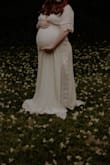 I purchased this dress in a Medium for my maternity photos. It fit perfectly and true to size! I am on the shorter side, so it did run a little long! But overall, I loved the fit of the dress, and the style. I was 32 weeks pregnant when I had these pictures done, and there was still room for my stomach to grow! 10/10 would recommend! - Taylor M.