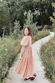Got this dress to wear to a wedding. It's such a dreamy dress with puff sleeves and an open back. I got so many compliments. I felt it was true to size. The fabric is soft, comfortable, not sheer or see-through, and very easy to wear and dance in. I wore a backless stick-on bra, but I think some could opt to be braless and still feel supported. Absolutely love this dress and can't wait to wear it again. - Kyra W.
