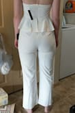 Firstly, what a convoluted process just to leave a review! I ordered this pantsuit to wear for my Bachelorette party. I tried it on and the first thing I noticed is how heavy the material was for something strapless. The material is very stretchy, which is comfortable, but the overall weight pulls the pantsuit down with every step. The girls popped out just walking across the room. The other glaring issue is the top has 2 layers of material which causes it to curl/fold under so the silicone grippy at the top rolls to the outside. That further compromises the integrity of the strapless top. The zipper is also very difficult to get past the ruffles; I required assistance just to zip/unzip (not ideal for a pantsuit that requires frequent zipping). Nextly, I ended up with a wedgy just to keep the girls covered. I can't go in public in this for fear of arrest related to public indecency. Don't bother with this unless you are bringing your breasts as party favors. - Emilee C.