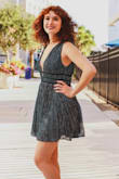 The dress is made of a nice material.  It is lined.  The shoulders have a nonslip grip strip.  It has a nice weight to it that keeps the material in place with a nice flow.  The price is great. The color is a rich teal with silver and black shimmer vertically.  The waist is a velvet ribbons- nice quality.  I got a medium.  The rib area was a tad loose but we tacked in a strip of 3/4
In elastic and it was great.   Lulus shipped earlier than expected which was also nice. - Dina B.