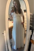 I'm so in love with this dress!! I never purchase much clothing online, let alone a wedding dress without trying it on first! But this dress felt like it was made for me. I ordered an XXS due to my usual size of XS being out of stock. I was really worried it would be too small but it even has a little wiggle room in the bust. I read reviews about going down a size from what you usually wear, and I'm so happy I did. Pictures don't do this dress justice, I was surprised at the weight of it (in a good way!) it's very high quality material. The length is perfect, no alterations needed. I'm very small in the chest, no bra was worn in the pics. Easily can be worn with or without one. - Kristyn F.