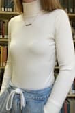I love this shirt! It fits great, looks great on its own and works great with layering too. The material is quite different than what I expected, it is very tight and stretchy, and kind of stiff. The shirt looks too small when you first get it, but it stretches when you put it on. It is a little see through, and bra lines are very visible due to its tightness and material. The sleeves are a little long, but you can roll them and it still looks good. The body is a perfect length. The neck looks good folded down when worn on its own, or looks good up with layering. It's very warm and comfortable. - Erica G.