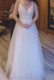 I wore this for my wedding and loved it! I wore flats, so I had to get the dress hemmed a couple of inches but it was easy to do since it was mostly tulle. There's 3 layers of tulle, a silk skirt, and then just a slip which I loved because unlike all the other dresses I tried on, it was not see-through!! It was so light and flowy- it also ended up raining most of our wedding day for pictures, but I didn't see much dirt/mud/grass stick to it which was nice! The bottom has sparkles which I didn't realize until I got it but I ended up loving it because it was still simple but not too plain for me! And can't go wrong for $250 :) and you can see in the pic just slightly, it didn't have a train but the back of the dress did come out a little. - Rebecca B.
