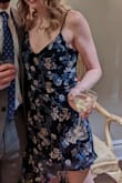 So this dress is pretty nice but the high low isn't as flattering as the picture. Notice how on the model the highest point is on a curve. On my dress, the highest point was on a straight line which looked like a straight across the normal short cut dress from the side. The cut does not swoop like the photo which made it feel a little awkward. Overall I'm happy with the dress and I'll wear it again. Great price, great quality, just not perfect. I'm between XS and S and ordered a S so it wouldn't be too short or chesty for a winter wedding. This worked out well. In the past, I've got into Lulus XS for a tighter look. - Caitlin T.