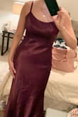 The material is amazing. Wine/purple with almost a holographic shine in the light. The fabric at the seams and zipper does bulge/stick out but that may resolve itself after the dress is steamed. I'm 5'6 and with 3 inch heels I don't think it will need to be hemmed. The adjustable straps are great too. Overall a classic dress to have in your closet - Caroline D.