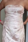 The dress is beautiful and so elegant! It is fully lined. My daughter loved it. The top fits perfectly but the bottom is a bit loose on the hips and also too long - will have to have it tailored. A bra is not necessary either because it offers support unless you are a bit heavy on top.
The fabric is thick and stiff as it looks on the model-which is what we were expecting. The colors of the embroidery are a mix of pink and metallics silver and gold.
The bow is a beautiful detail on the dress but it will be important to learn how to tie a nice bow instead of just the regular one I can tie.
I'm happy with this dress just what we were looking for. - Raquel M.