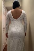 The dress is beautiful, and the color is white. It's not see-through, only on the sleeves. The pattern is different, which I love. The cut in the front and back is like a V shape, which makes you show cleavage (especially for me with medium-size breasts). I'm not wearing a bra or a corset in the pictures, so I can only imagine how better it would look if I did. I was worried about my back rolls showing in this dress, but they don't! The sleeves are too long, so I had to fold them in, as you can see in the picture by my wrists. The length of the dress wasn't too bad for me, especially when wearing heels. The tail is pretty long, but it looks beautiful! - Josselyn M.