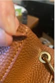 I bought this bag in October, 2020 and it started falling apart a little over a year later. The grommet where the strap attaches fell off and the material in another spot has a tear. The stitching is coming loose in another place.
I really liked this bag but it isn't durable for everyday use. I don't carry unusually heavy stuff in my bag - wallet, phone, keys, small makeup bag and that's it. No water bottle or tablet. Very disappointing because I liked the look of this bag. - Elise L.