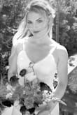 Our bride chose to put us bridesmaids in white for her wedding. This dress was extremely impressive, especially for the price point. It was exactly what I envisioned - both classic (white, detailed buttons down the back), modern (thin straps and the low back), and simple (the neckline with small lace detail). This fit me quite well and hugged in all the right places! I suggest ordering the downsize if you're on the fence - I ordered an XS instead of a Small & was very happy! I have a shorter torso so the straps would've been too long w/a S (material didn't lay flat where straps and bodice meet, but no biggie with long hair). XS was plenty long on 5'1" frame + heels (may want to alter). Material was plenty thick (quality), but you may want to wear seamless undies/thong or shapewear. No trouble with a backless "sticky" bra - 36B/34C. This dress worked well for me, but white isn't too forgiving by nature so I'd recommend for fit frames because of the form fit of this dress. - Michaela J.