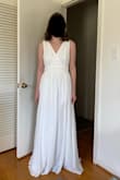 I bought a M to try on for a wedding dress option for my wedding in Greece later this year. It's a very nice dress and fits well, especially if you are tall - I will probably have to hem it even though I'm 5'10", since I'm not wearing heels. I'm going to need to take in the waist a little to make it look a little more shapely on me, since the waistband is a bit loose on my body. I'm also going to adjust the underskirt so that the slit doesn't end up showing quite so much leg (you can see in the attached picture that the underskirt slit ends slightly higher than the outerskirt slit. These are manageable adjustments - my biggest issues is that the material is see-through enough that the bodice ends up showing that overlapping triangle in the front, which I don't like. I didn't see this in the consumer pictures when I bought it because it depends on your bust size and what color dress you buy. - Marina B.