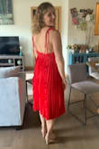 Wore this dress as a guest at a summer wedding and loved it! Super fun with the long flowy skirt and got a lot of compliments on the back. I originally ordered the dress in the teal size medium. I was able to close the zipper in the back, but it was ultimately too tight as the waist is woven and has no give. The waist falls a little lower to give the low back look so it hit below the true waist which didn't help. Also with the medium, I didn't think there was enough coverage for a bigger chest. When I went to order a size up the red was available so I went for that. The teal color was nice, but I'm so happy I went with the red as it was much more summery. The large was actually a little big in the waist so I tightened it up a bit by adding an extra snap. The bust size with the large was much more appropriate and I wasn't worried about being too exposed without wearing a bra. - Amanda L.