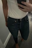 I originally ordered this in a Small and while it fit well on top, it was just a touch too short (riding up a bit more than I'd like and you could see the seam where the front of the shirt meets the body suit underneath - even wearing high waisted jeans (not a cute look). So, I returned hoping the Medium would be a touch longer and the fabric in the front an inch or 2 longer.... Not the case. Received the Medium and the top part is a bit looser (which I don't particularly care for as the sleeves don't feel as secure on my shoulders) and, you guessed it, you can STILL see the seam where the front of the shirt meets the under part. If I don't move and just stand there my jeans just kiss the seam, but let's be honest, I plan to move in this haha. Love the look of this shirt otherwise, but just wish the material was a couple of inches longer in the front for us longer-waisted girls! - Emily H.