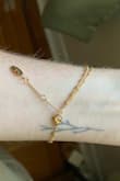 Sooo dainty. The smallest little chain. I love it, very cute. I have it on the tightest hook (3 hook options). I've worn it a few times and hasn't seemed to lose its gold/tarnish at all. - Andrea L.