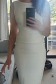 Material is thick, not see-through, and slightly stretchy. The fit is tight, but still easy to move and sit comfortably. The quality material and high-cut neckline in the front, coupled with the just-below-knee length make this dress ooze timeless class. Meanwhile the figure-hugging shape and low back make this dress an absolute bombshell. Warning, high beams can show through the material -- I'm personally going to use pasties, but more well-endowed ladies may need tape (the dress is not that supportive for the gals). Ensure you can get seam-free underwear, and be careful that any shapewear doesn't come up too high or it can be seen due to the low back. Bought this as my courthouse wedding dress, and can imagine being able to wear it out for anniversary dinners for years to come. Very Happy!! - Kate B.