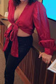 Beautiful silky red shirt. Can be tied in the front for a deeper V or crossed and tied in the back. I'm a little curvier so I liked that by tying it in the front the sides came down far enough to cover my sides which I don't love showing. Lots of cleavage of course and just a peek of front belly. Definitely give it a try! I got a ton of compliments. - Rosanne G.