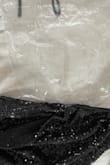 I opened the package and all the tiny black pieces on the shirt shed/fell off all over my bed and floor. Impossible to wear as it sheds like crazy and makes a huge mess. The picture is only a fraction of the shedding as I immediately took it to the trash to shake it out. - Emily P.