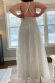 I was suuuper excited to try on this dress. It's gorgeous! And the skirt definitely was (look at how the light shines through it!!!)! But the bodice looks absolutely nothing like it does in the photo. First, the neckline doesn't have the defined swoop into the V like you can see on the model. The actual dress had a lot of loose tulle fabric, making the swoop and V messy-looking and less elegant. Second, the model-image looks like there is more structure and shape in the bodice, but there is neither, making it a bit unflattering for bigger chests. The shape looks more like the sundresses I wore in middle school :( I really wish it were not the case, since I LOVED the skirt so much. Also, it is very long, which was expected! - Christiane L.